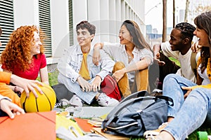 High school student friends hanging out at campus grass.