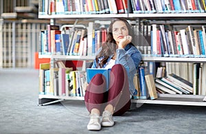 High school student girl reading book at library