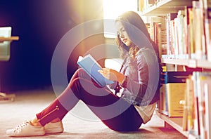 High school student girl reading book at library