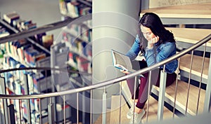 High school student girl reading book at library