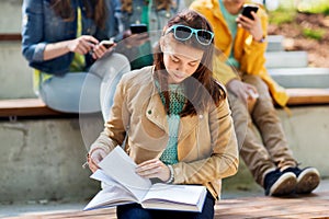 High school student girl reading book outdoors