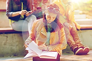 High school student girl reading book outdoors