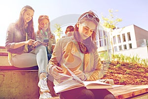 High school student girl reading book outdoors