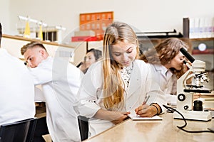 High school student with microscopes in laboratory.