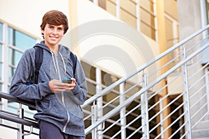 High School Student Standing Outside Building With Phone