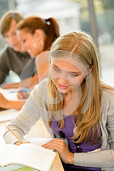 High-school student taking notes in library study