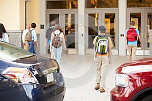 High School Students Being Dropped Off At School By Parents