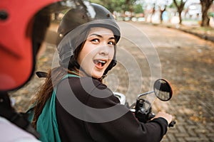 High school students looking back chatting while riding motorbikes together