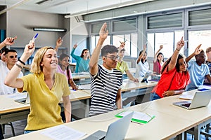 High school students raising hand to ask a question during lecture in classroom