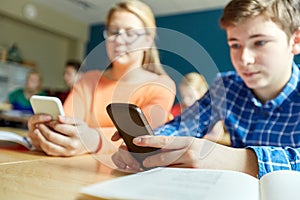 High school students with smartphones texting