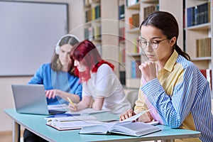 High school students studying in library class, teenage girl in focus