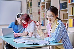 High school students studying in library class, teenage girl in focus