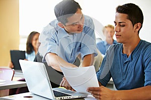 High School Students With Teacher In Class Using Laptops