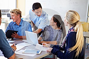 High School Students With Teacher In Class Using Laptops