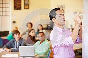 High School Students With Teacher In Class Using Laptops