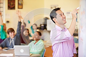 High School Students With Teacher In Class Using Laptops