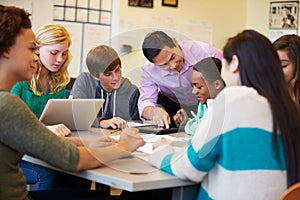 High School Students With Teacher In Class Using Laptops