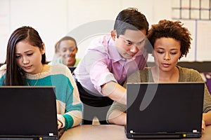 High School Students With Teacher In Class Using Laptops