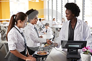 High School Students Wearing Uniform Paying For Meal In Cafeteria