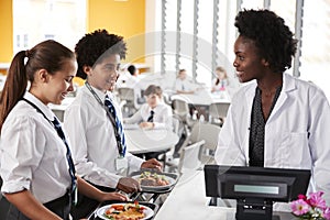 High School Students Wearing Uniform Paying For Meal In Cafeteria photo