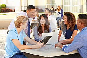 High School Students Working On Campus With Teacher