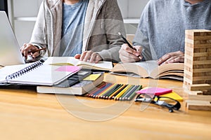 High school tutor or college student group sitting at desk in library studying and reading, doing homework and lesson practice