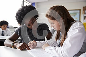 High School Tutor Giving Female Student Wearing Uniform One To One Tuition At Desk photo