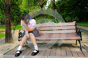 High-Schoolgirl crying alone on the bench