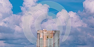 High section of modern skyscraper hotel against big rain clouds on blue sky background before raining