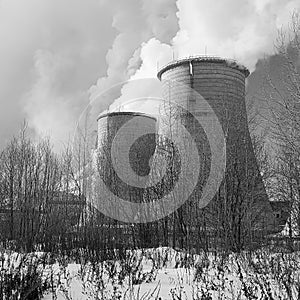 High Smoking thermal power plant stands on the snow and pollutes the environment