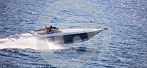 High-speed boat goes fast in calm sea. People enjoy the summer sport.