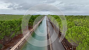High-speed drone flight over the Tajo-Segura water transfer canal in Spain and hovering over it showing a grove of trees next to