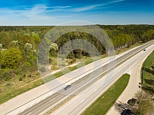 High-speed highway and railway, top view. Green field and blue sky.