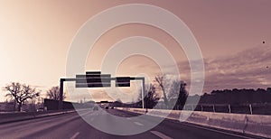 High speed highway with signage against dark sepia sky