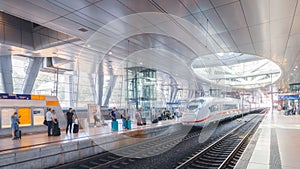 High-speed ICE train at the airport's long-distance station with people waiting on the platform