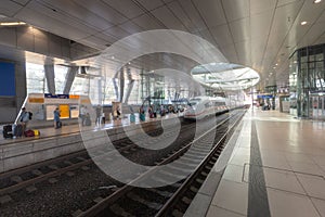 High-speed ICE train at the airport's long-distance station with people waiting on the platform