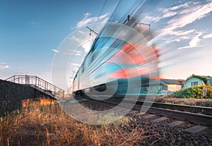 High speed passenger train in motion on the railroad at sunset
