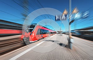 High speed red train in motion on the railway station