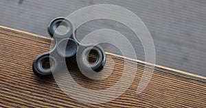 A high speed spinning hand spinner or fidget spinner over the wooden background.