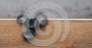 A high speed spinning hand spinner or fidget spinner over the wooden background.