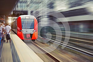 High speed suburban train with motion blur rides city station
