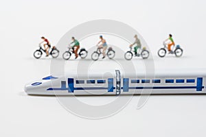High speed train model and miniature people riding a bike