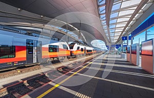 High speed train on the modern railway station at sunset