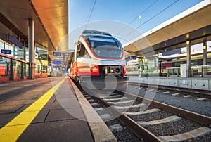 High speed train on the modern railway station at sunset