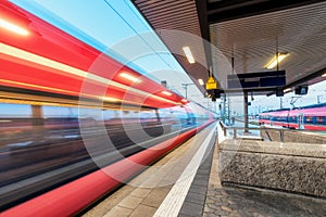 High speed train in motion on the railway station at dusk