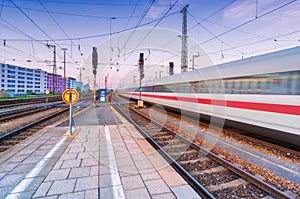 High speed train in motion on the railway station at dusk