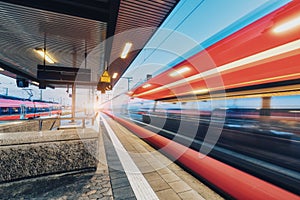 High speed train in motion on the railway station at sunset