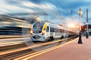 High speed train in motion at the railway station at sunset