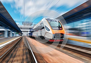 High speed train in motion on the railway station at sunset