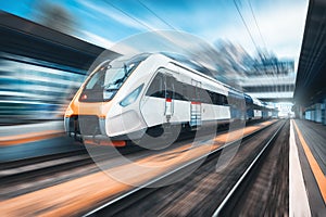 High speed train in motion on the railway station at sunset